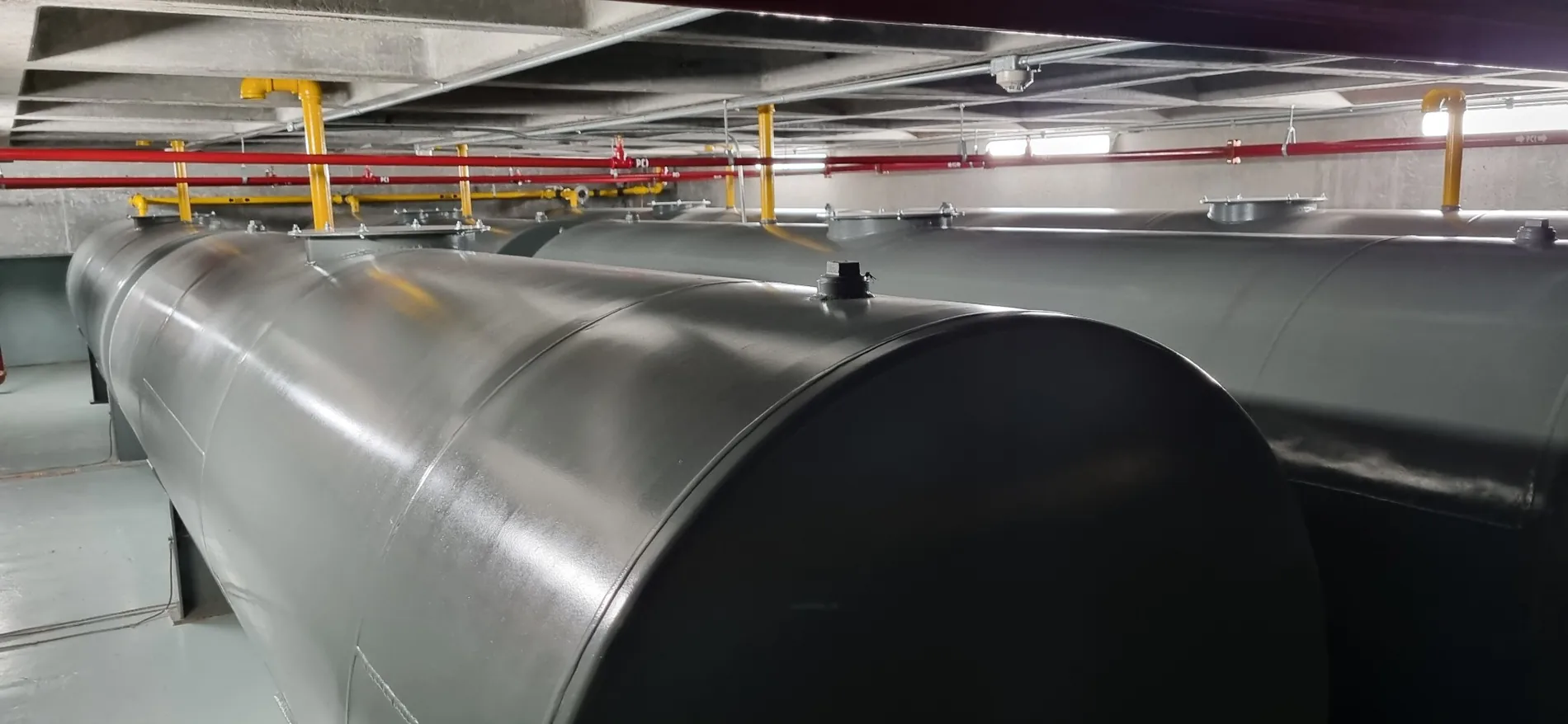 Tanques horizontales metálicos instalados bajo cubierta con tuberías visibles