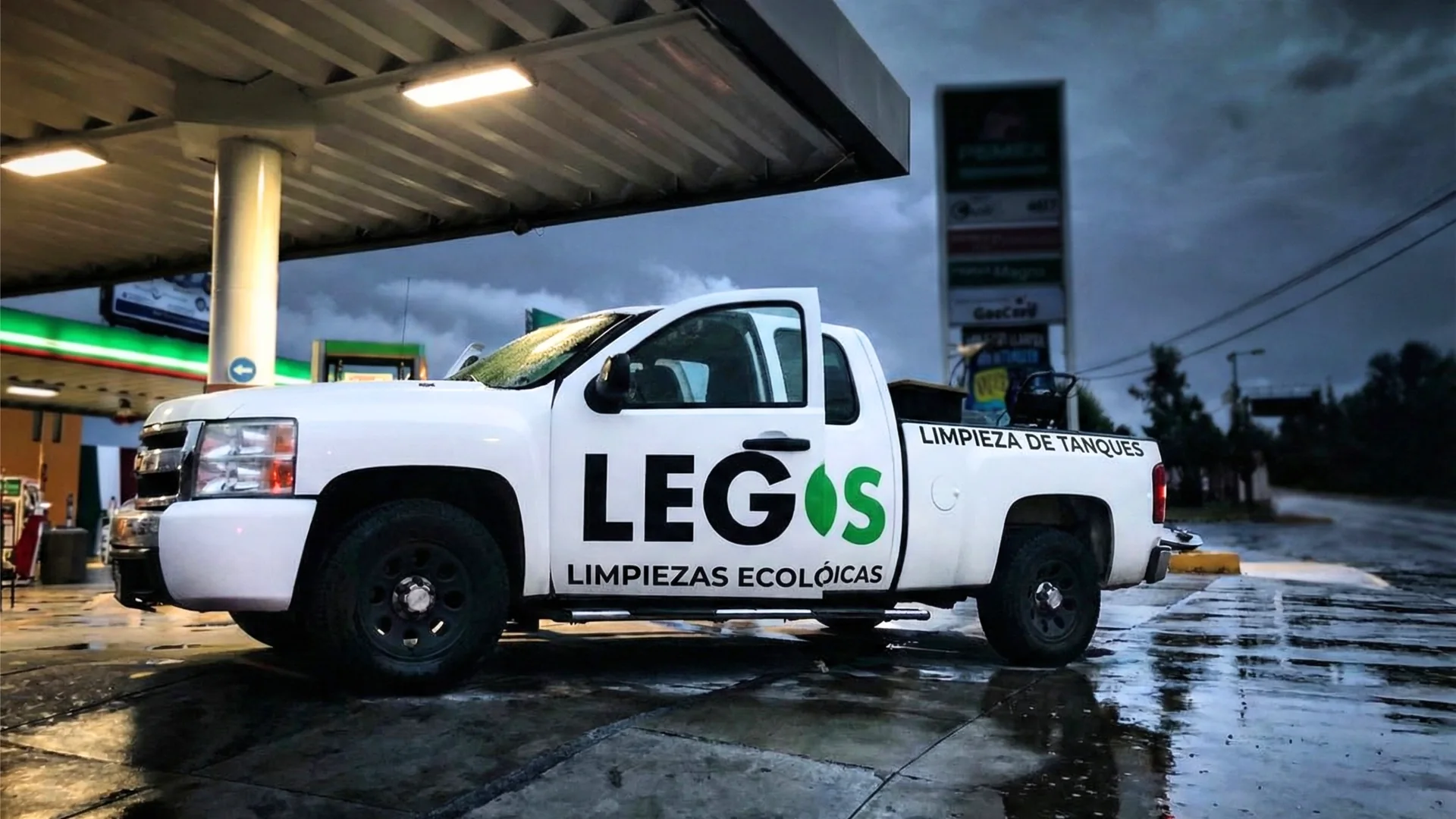 Camioneta de LEGOS Limpiezas Ecológicas en una estación de servicio al anochecer.