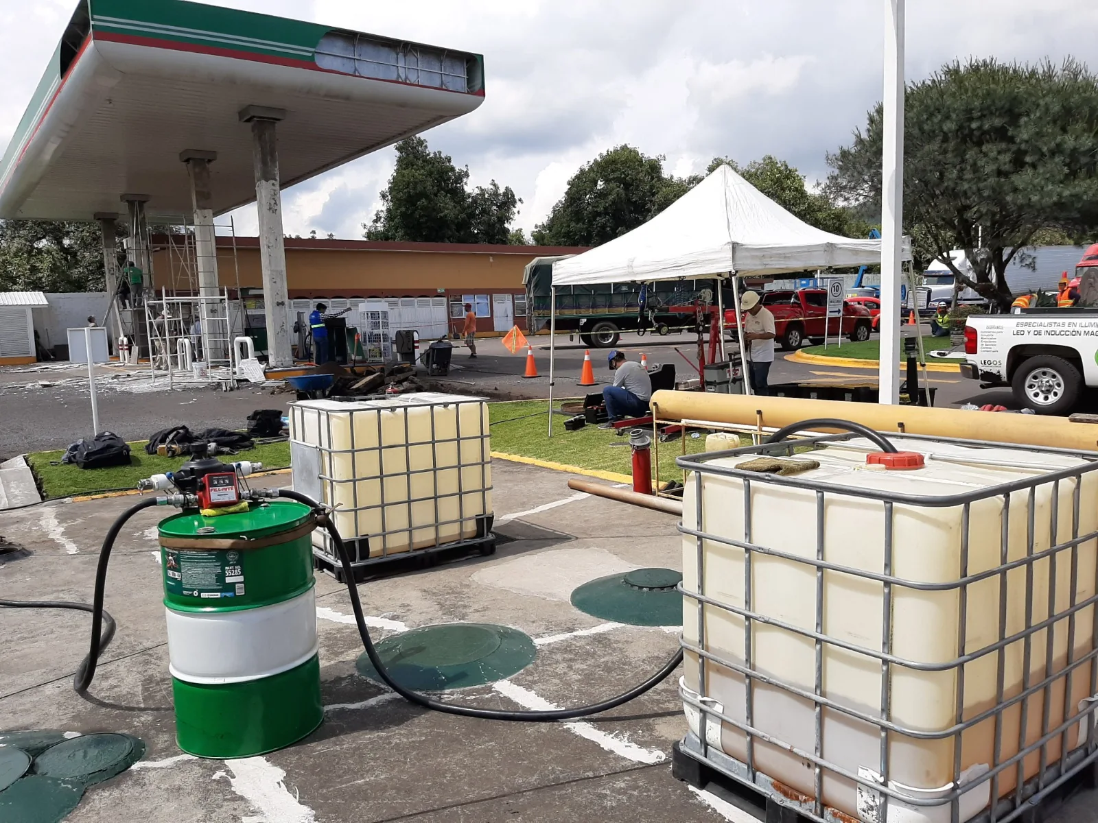 Equipos de limpieza junto a los accesos de tanques en una estación de servicio.